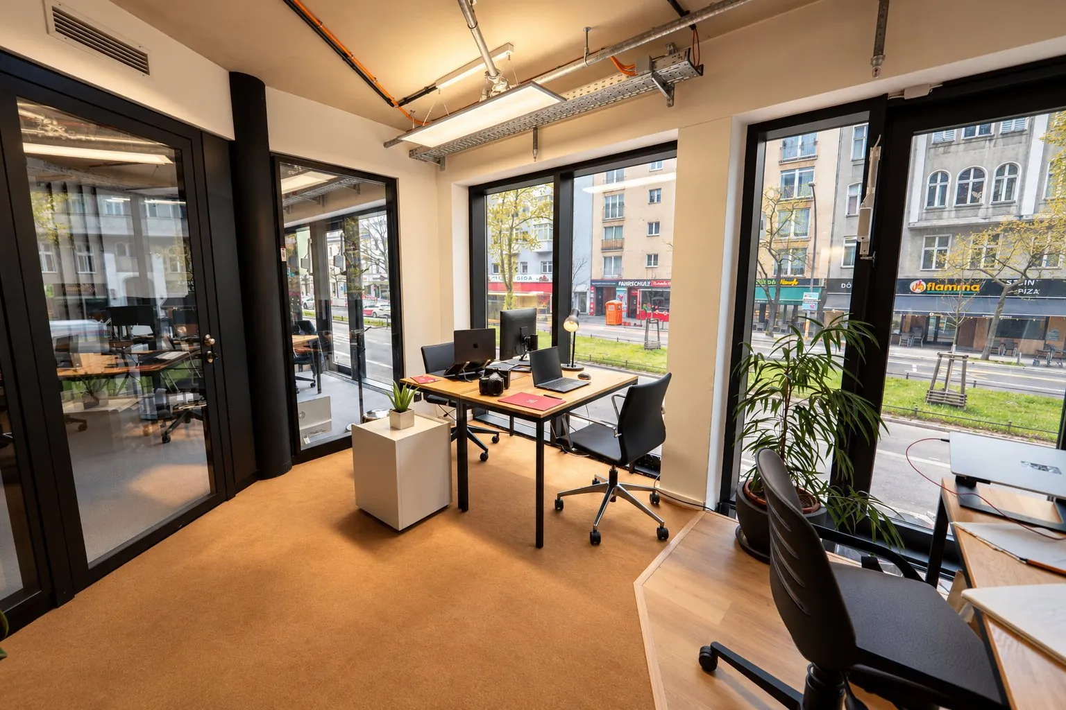 Ein Arbeitsplatz im PraxisPush-Büro mit Kamera auf dem Tisch und Blick auf die Straße